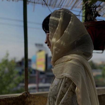 A woman wearing a head covering looks away from the camera
