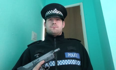 Reed Wischhusen in police uniform holding a gun.