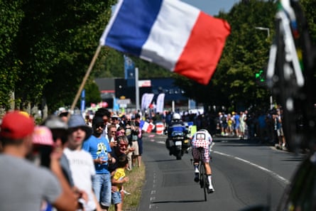 Tadej Pogacar cycles nether a French flag.