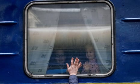 Children in an evacuation train from Kyiv to Lviv say goodbye to their father