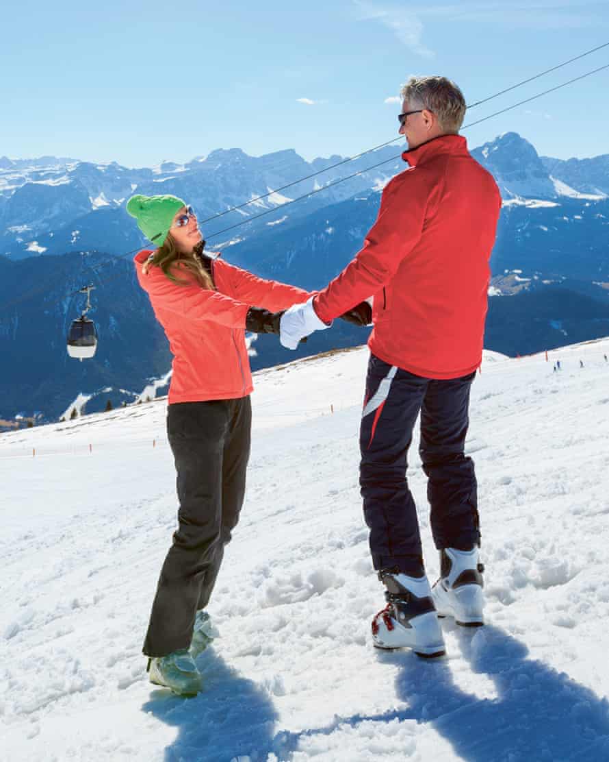 Couple holding hands on ski slope
