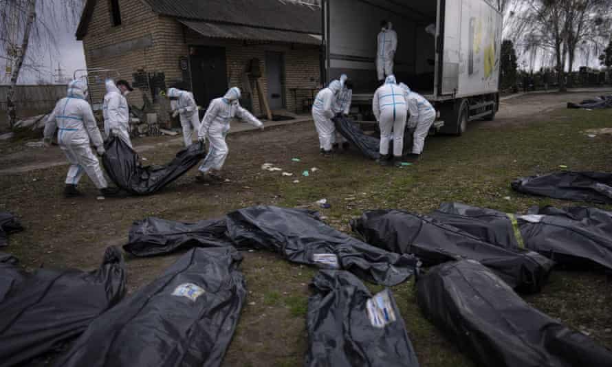 Volunteers load bodies of civilians killed in Bucha on to a lorry