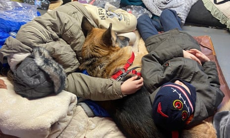 Alisa’s family and dog huddle together on the floor after arriving in Poland from Ukraine.