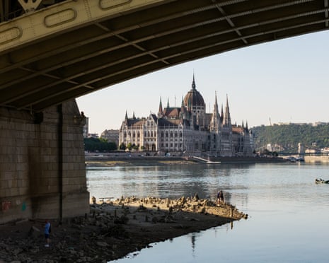 A drone view shows people walking at the base of a pillar of Margaret Bridge, revealed by the low water level of the Danube River in Budapest, Hungary.