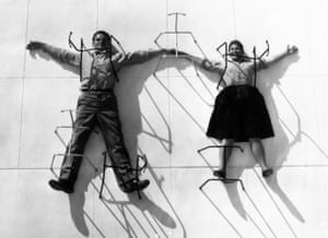 Charles and Ray Eames posing with chair bases.