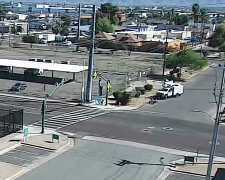 A screenshot from surveillance footage shows a person stopping a child from running on to a street, circled in blue