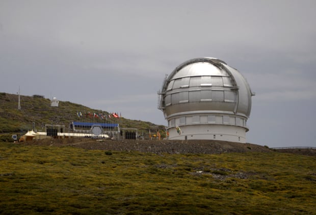 A large white spherical structure sits on the top of a mountain.