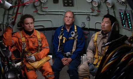 Finn Cole as Chris Lemons Woody Harrelson as Duncan Allcock and Simu Liu as Dave Yuasa in Last Breath, sitting in an underwater vessel wearing overalls in the film Last Breath.
