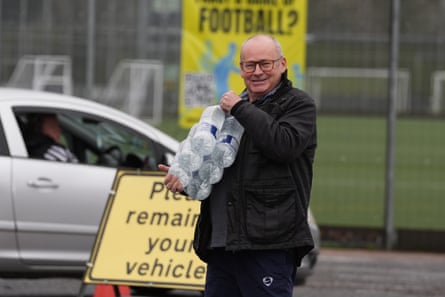 A man collects bottled water from a water station in East Grinstead