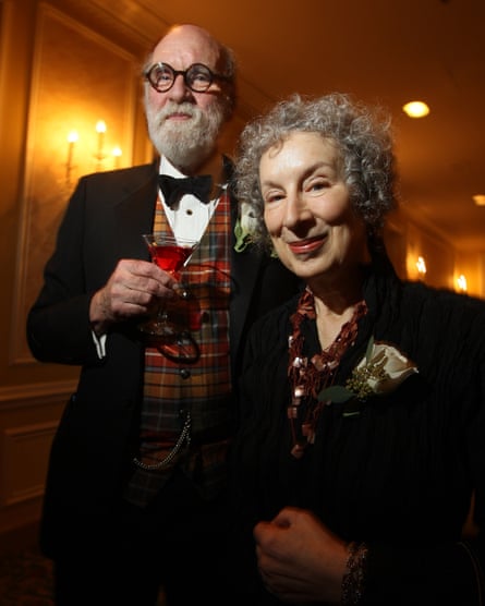 Atwood and Gibson are smartly dressed and smiling at the camera. Gibson is holding a cocktail