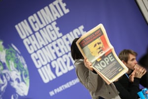 A delegate holds a poster accusing Joe Biden of breaking his climate promise