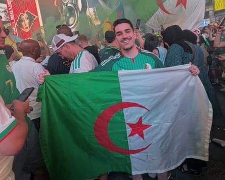 Lyés Bouzidi holds up an Algeria flag in New York’s Times Square