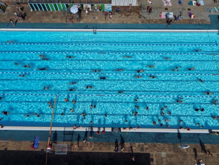 A drone shot showing people swimming in an outdoor pool