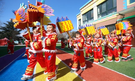 Children dressed up and performing a dance at a kindergarten in China.