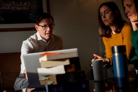 A man and two women speak inside an office