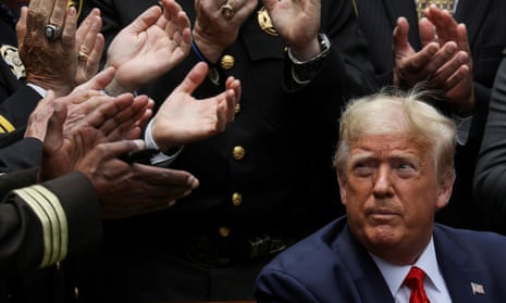 Donald Trump listens to applause after signing an executive order at the White House in June 2020.