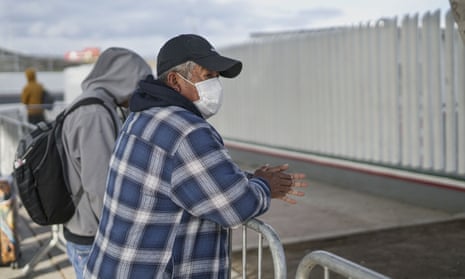 A Honduran migrant wears a mask while waiting in line to plead for asylum in Tijuana, Mexico. 