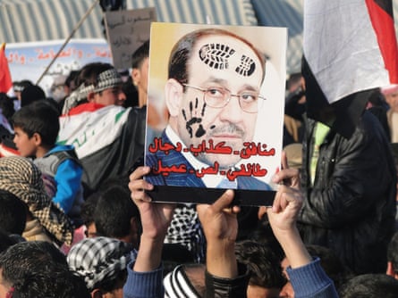 Iraqi Sunni protesters hold up a portrait of prime minister Nouri al-Maliki with slogans reading in Arabic, “liar … sectarian, thief, collaborator” during a protest against him on the main highway to Syria and Jordan near Ramadi, Anbar’s provincial capital west of Baghdad, on 4 January 2012.