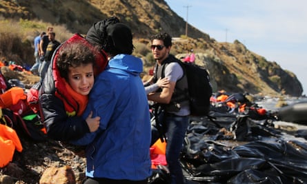 People are assisted moments after they arrive with other Syrian and Iraqi refugees on the island of Lesbos from Turkey