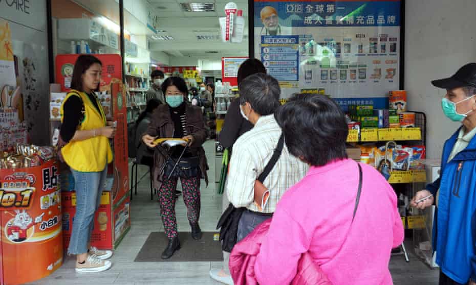 People queue up to buy face masks at a pharmacy in Taipei, Taiwan