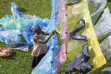A Ugandan woman hangs cleaned waste plastic out to dry.
