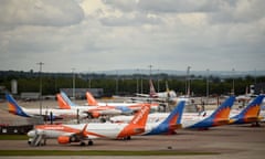 BRITAIN-IRELAND-HEALTH-VIRUS-AVIATION<br>Aircraft grounded due to the COVID-19 pandemic, including planes operated by TUI, EasyJet and Jet2, are pictured on the apron at Manchester Airport in Manchester, north west England on May 1, 2020. - Irish low-cost carrier Ryanair said on Friday it planned to axe 3,000 pilot and cabin crew jobs, or 15 percent of staff, with air transport paralysed by coronavirus. Dublin-based Ryanair added in a statement that most of its flights would remain grounded until at least July and predicted it would take until summer 2022 at the earliest before passenger demand recovers. (Photo by Oli SCARFF / AFP) (Photo by OLI SCARFF/AFP via Getty Images)