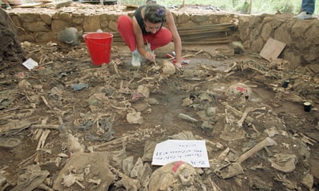 A forensic anthropologist brushes dirt from human remains in El Mozote in 1992. Campaigners hope that the reopening of the case will bring the killers to justice.
