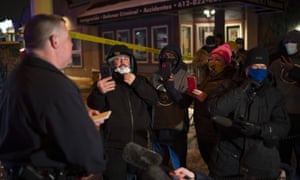 Minneapolis Police spokesman John Elder briefs community members and others about the shooting