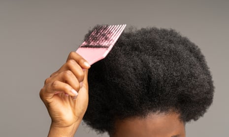Person combing afro hair.