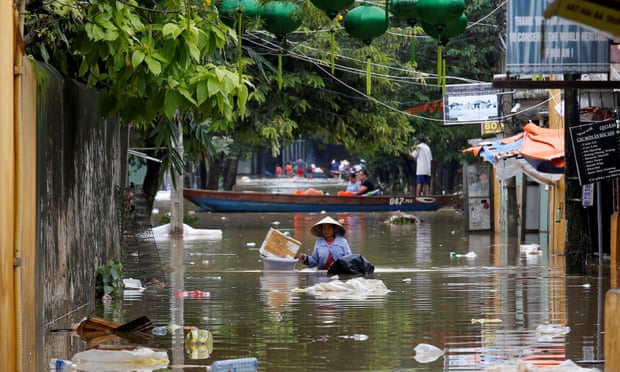 A woman wades past buildings flooded by Typhoon Damrey in the town of Hoi An in Vietnam’s south-central coast region