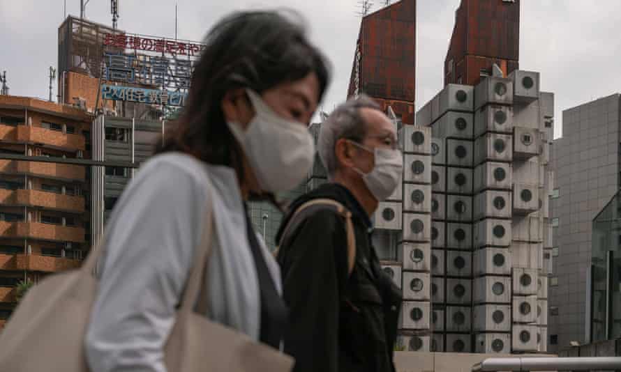 銀座の中銀カプセルタワービルを通り過ぎる歩行者