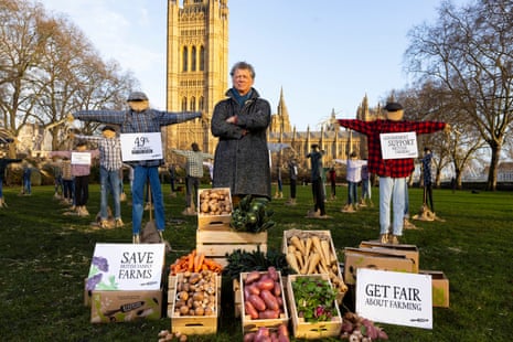 Riverford founder Guy Singh-Watson in front of 49 scarecrows outside the Houses of Parliament in London, as part of Riverford's 'Get Fair About Farming' campaign
