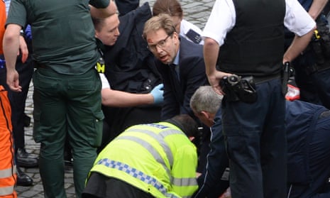 Conservative MP Tobias Ellwood (centre) helps emergency services attend to a police officer outside the Palace of Westminster, London, after a policeman was stabbed and his apparent attacker shot by officers in a major security incident at the Houses of Parliament. PRESS ASSOCIATION