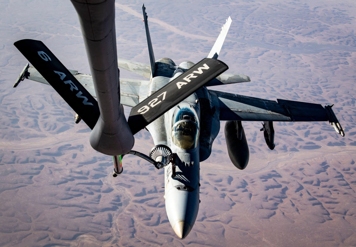 View from refuelling plane looking down at the Hornet jet, which has fuel nozzle leading down to it