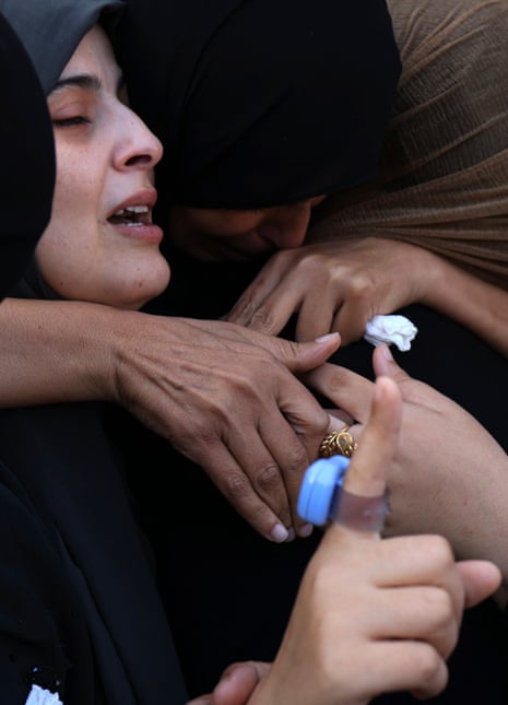 Palestinian women from the Abu Taim family comfort each other as the bodies of relatives are collected for burial from the al-Nasser hospital in Khan Yunis in the southern Gaza Strip on 9 November 2023.
