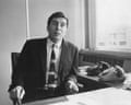 David Fairhall sitting behind his office desk next to two rotary telephones