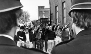 National Front supporters give a Nazi salute to  a police cordon, east London, 1979.