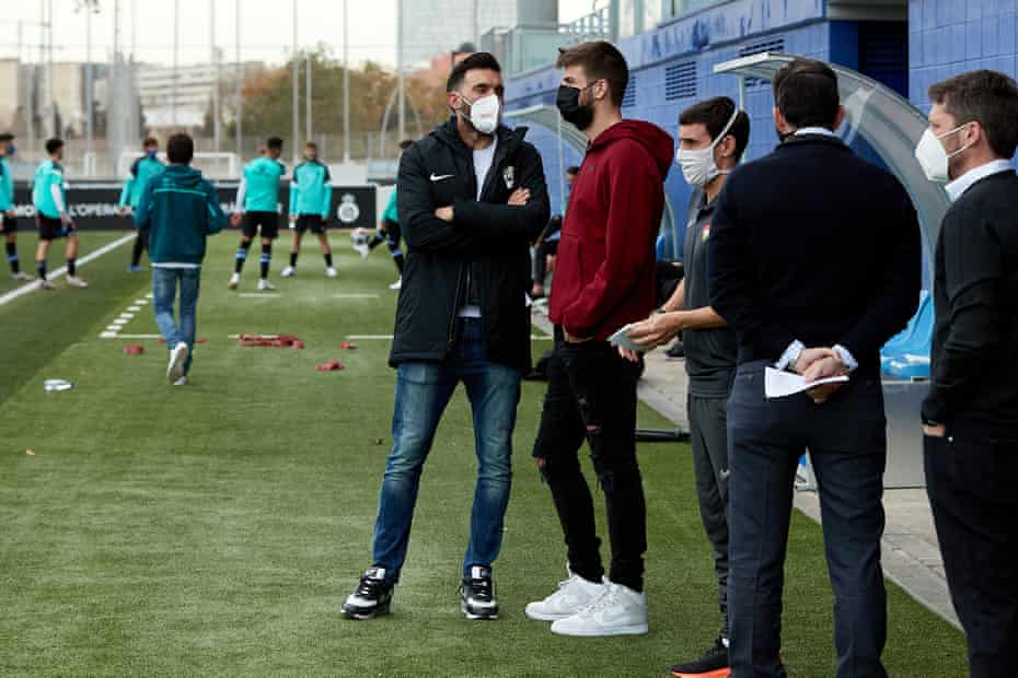 Club owner Gerard Piqué speaks with FC Andorra manager Sarabia as he visits his team during their Segunda B match against RCD Espanyol B in February.