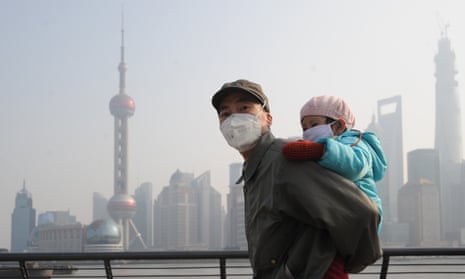 A man and his child wear masks in Shanghai, China in 2013, when annual deaths from air pollution were at their peak. 