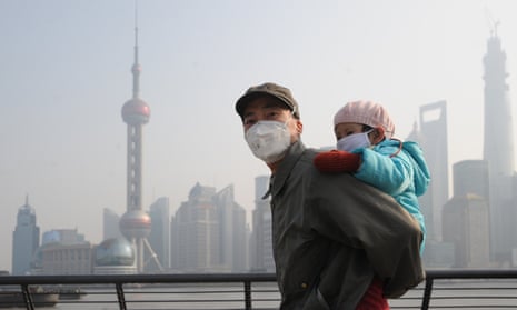 A man and his child wear masks on a smoggy Bund in Shanghai, China.