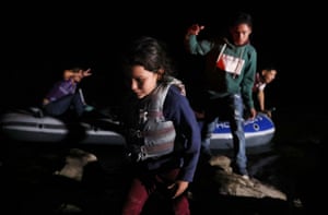 Asylum-seeking migrants disembark from an inflatable raft after crossing the Rio Grande river into the United States from Mexico in Roma.
