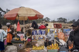 A vendor rests on a wall at a street market in the district of Kangemi in Nairobi