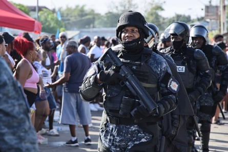 a line of armed police stand at an outdoor festival