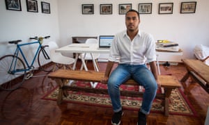Rashiq Fataar, founder and director of Future Cape Town, an independent non-profit organisation, sits at a table in a white studio space.