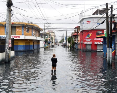 A woman standing in a flood street in Santo Domingo, Dominican Republic.
