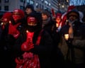 people hold candles at a vigil outside