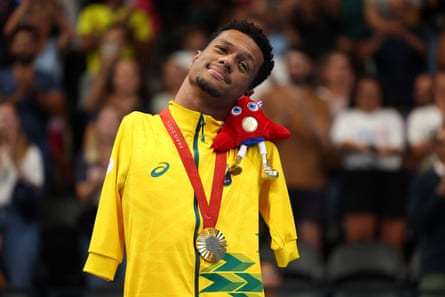 Gabriel Araújo on the podium with his gold medal and the Paris 2024 mascot on his shoulder