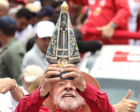 Lula da Silva holds up a statue of Our Lady of Aparecida at a campaign rally