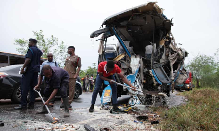 Fire service personnel clean up debris at the scene of a bus crash in Kintampo, Ghana