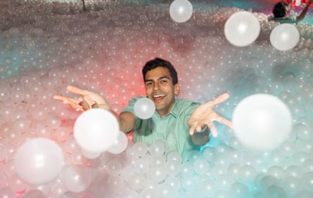 He holds his hands out to throw clear bubble-like plastic balls